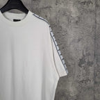 Balenciaga white crewneck T-shirt close-up of shoulder and patterned stripe sleeve trim