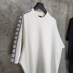 Balenciaga white crewneck T-shirt with patterned stripe trim on sleeves, side view