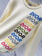 Cream knit sweater sleeve close-up with "DIOR" lettering and ribbed neckline
