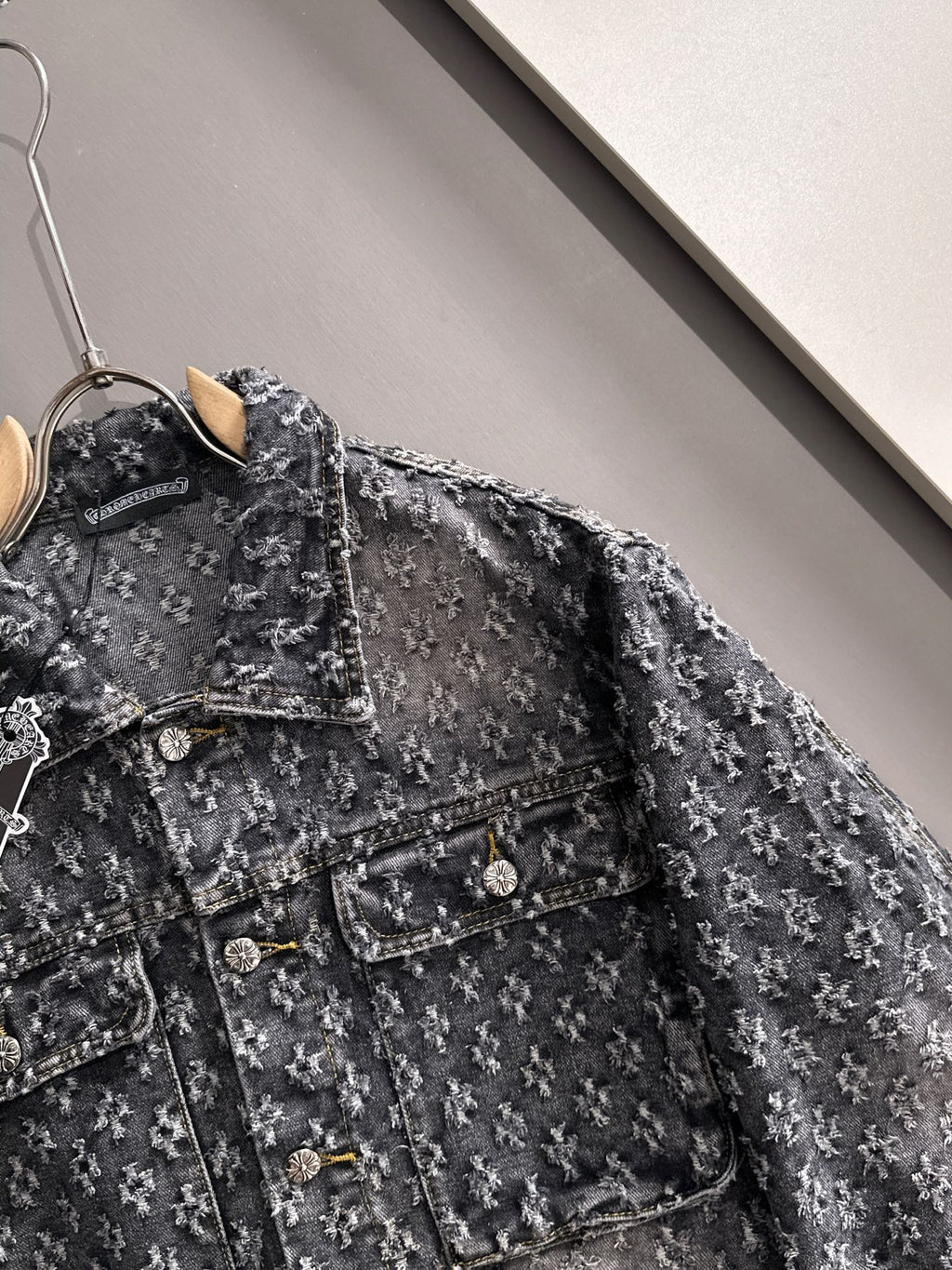 Distressed denim jacket close-up with flap pockets and buttoned front