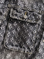 Distressed denim jacket pocket detail with coin-stud emblem and stitched trim