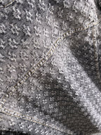Distressed denim jacket fabric close-up with textured embroidery and contrast seam
