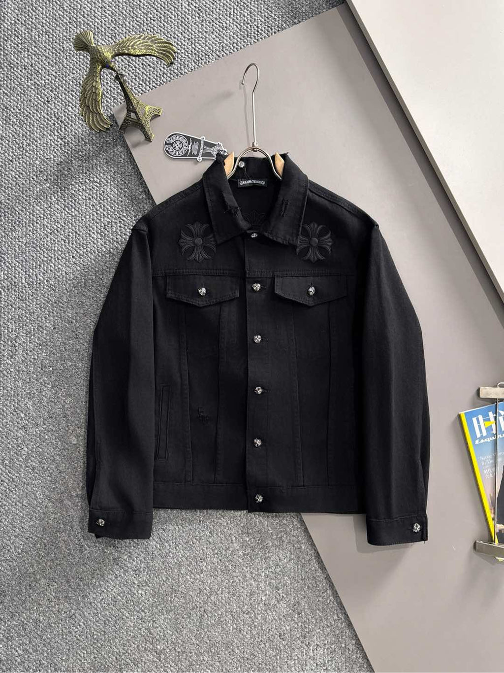 Black button-front denim jacket with floral embroidery on chest pockets