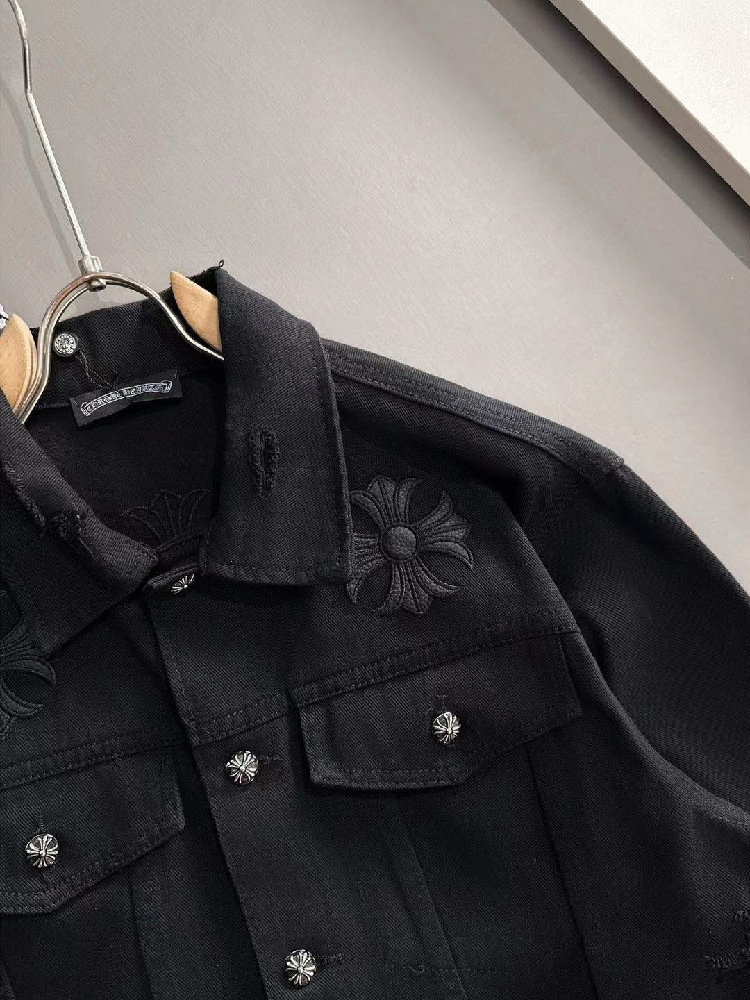 Black denim jacket with embroidered flower details and flap chest pockets