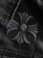 Embroidered floral patch on black denim with round silver button center