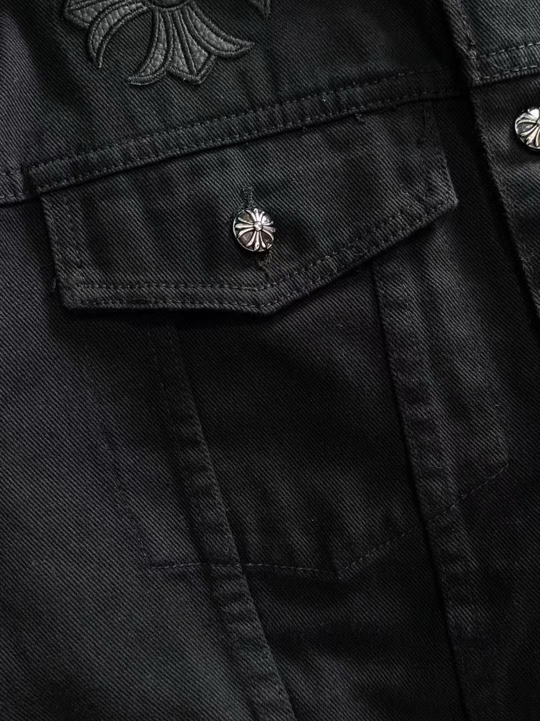 Black denim jacket flap pocket with silver stud button and stitched paneling