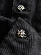 Black denim jacket collar with two silver floral stud buttons
