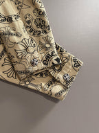 Long-sleeve shirt sleeve cuff with embroidered flower motifs on beige fabric