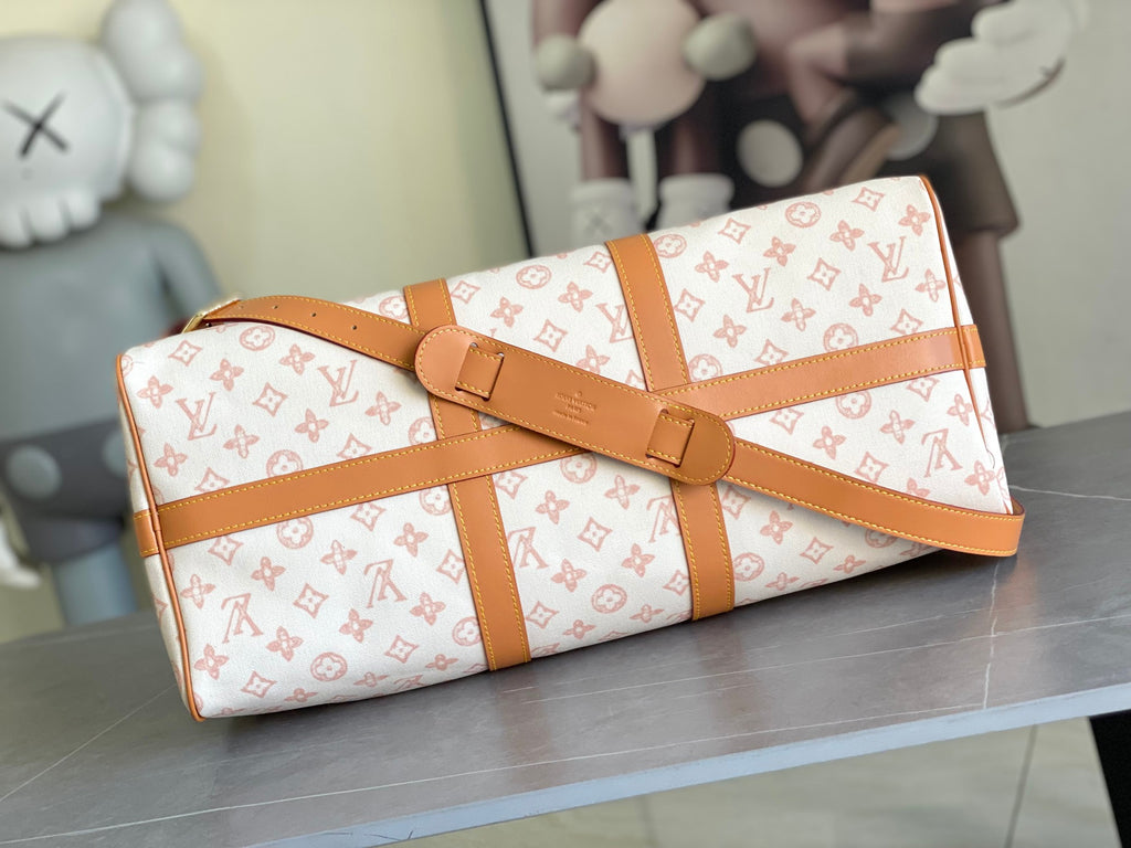 Monogram duffle bag with tan buckle strap and structured sides