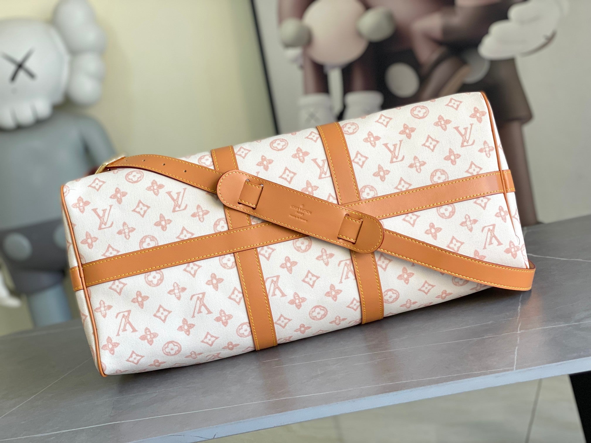 Monogram duffle bag with tan buckle strap and structured sides