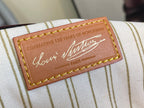 Brown leather brand patch with stitched border on striped monogram canvas
