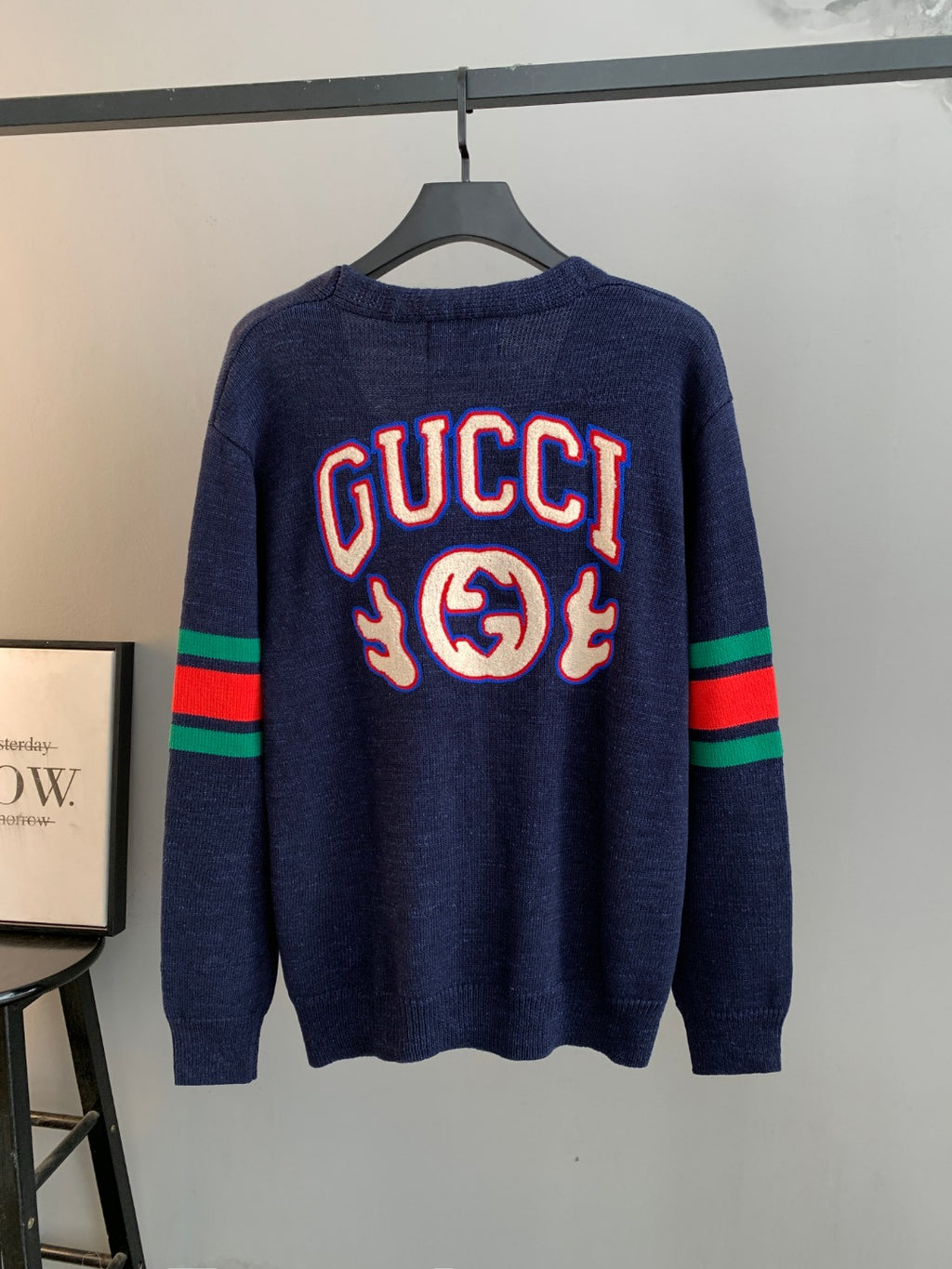Navy knit cardigan with large Gucci logo graphic on back and striped cuffs
