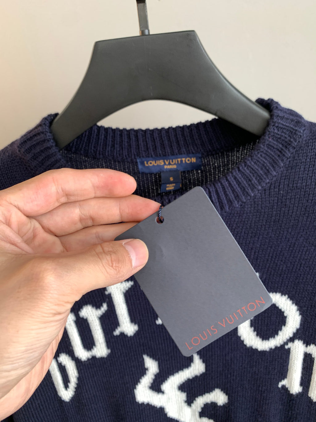 Navy long-sleeve sweater with Louis Vuitton neck tag and attached gray label