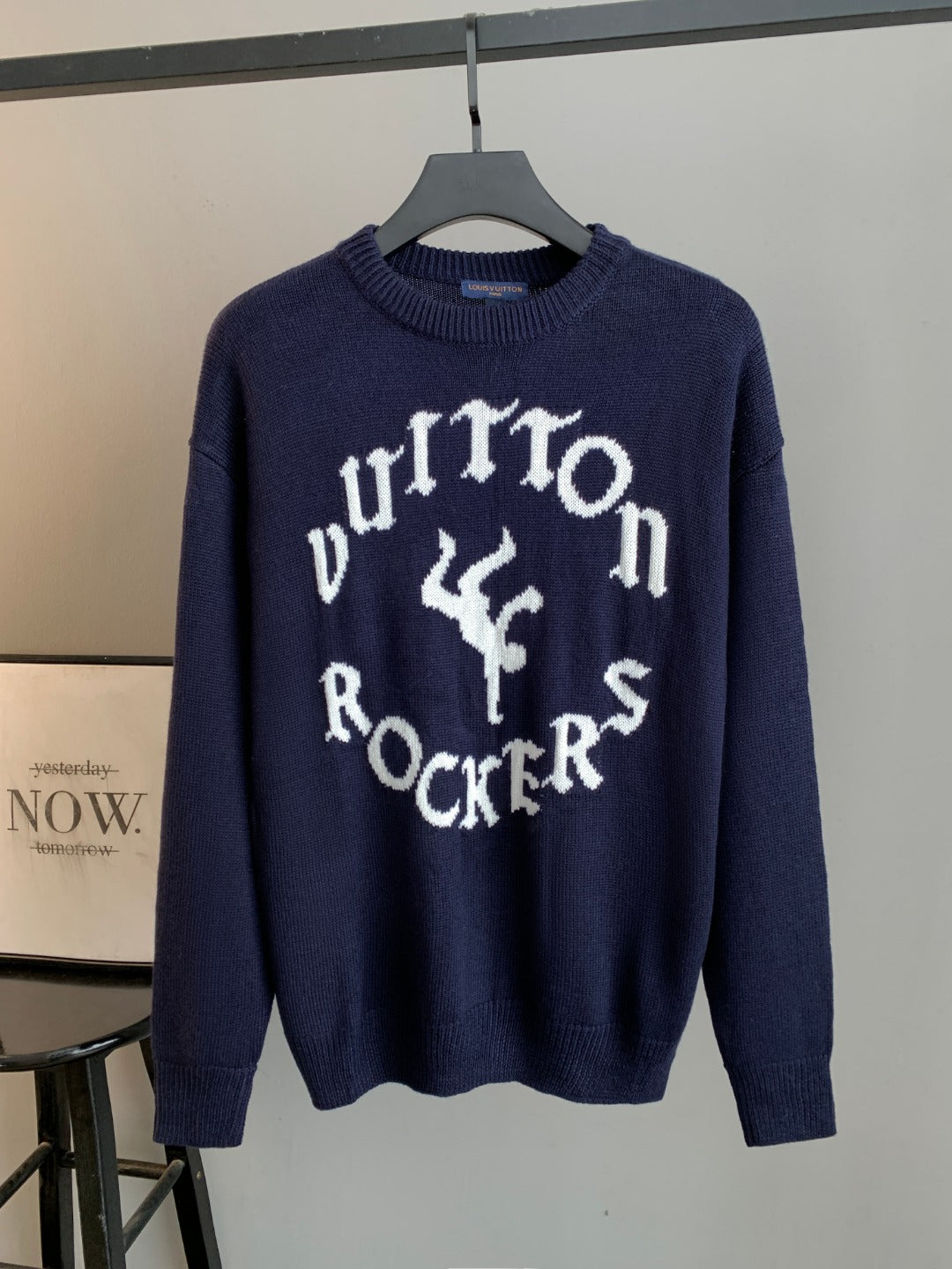 Navy knit long-sleeve sweater with large white graphic script and letters at center