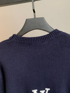 Navy crewneck sweater back close-up with ribbed collar and small white logo
