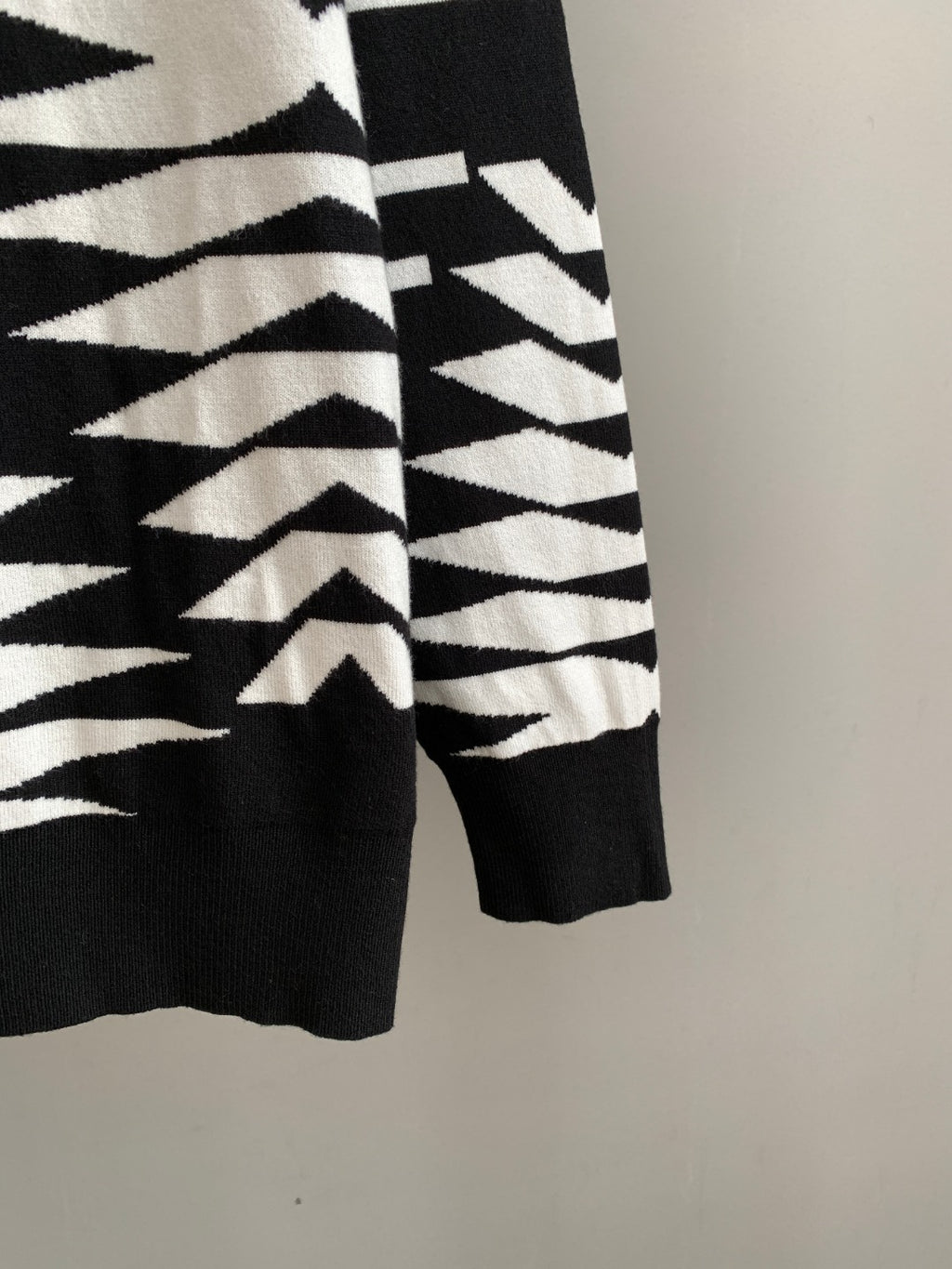 Knit sweater hem and sleeve cuff with black-and-white geometric print
