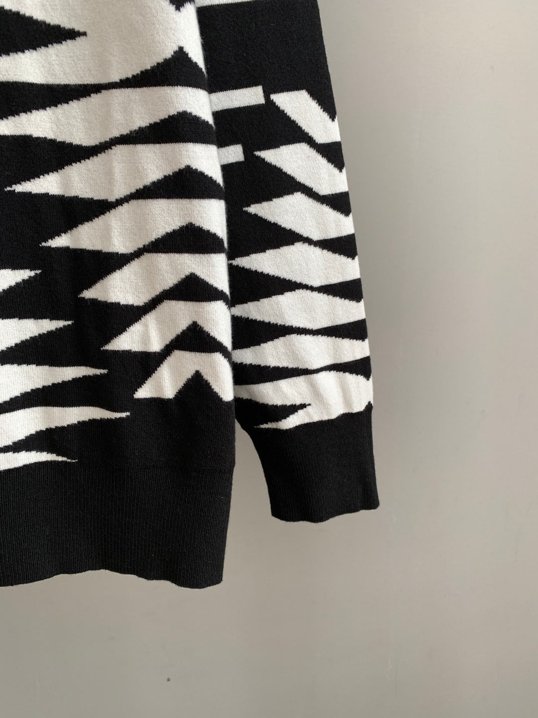 Crewneck sweater hem and sleeve cuff in black with black-and-white geometric knit