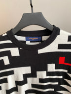 Knit sweater neckline with black-and-white geometric pattern and red accent