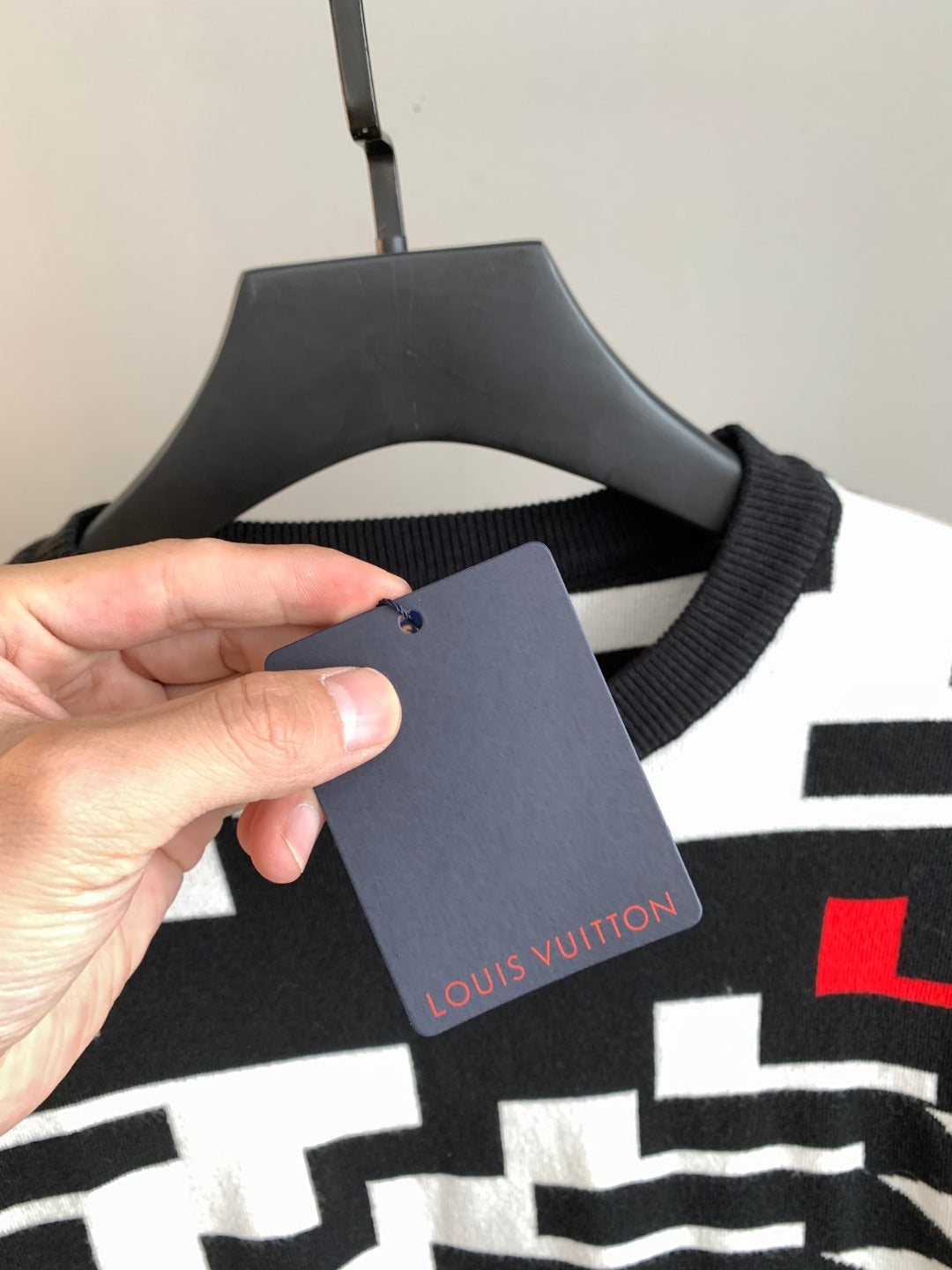Knit sweater hanging tag on black-and-white geometric sweater