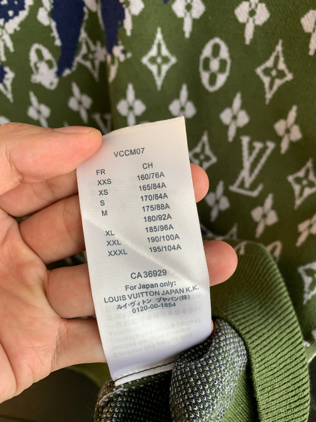 Louis Vuitton size label on green knit sweater showing size codes and values