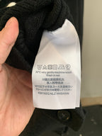 Care label inside the collar of a dark knit cardigan