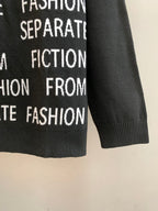 Black long-sleeve sweater with ribbed cuffs and repeating white text print