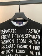 Black long-sleeve crewneck sweater with repeating white "Fashion" and "Fiction" text