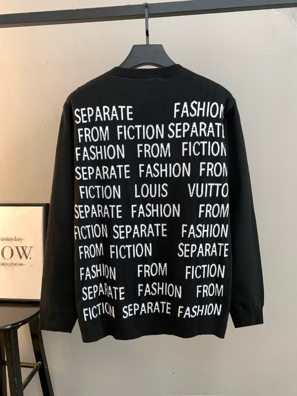 Black long-sleeve crewneck sweater with repeating white "Fashion" and "Louis Vuitton" text