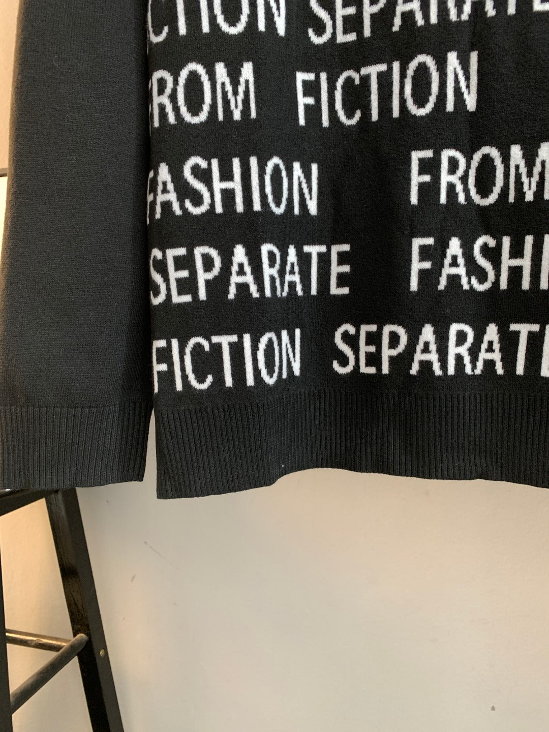 Black sweater front with repeating white "Separate" and "Fiction" text near hem