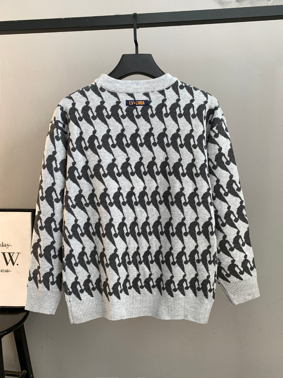 White and black patterned knit sweater back view, long sleeves, ribbed crew neck