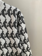 Long-sleeve sweater sleeve in light knit with repeating black silhouette pattern