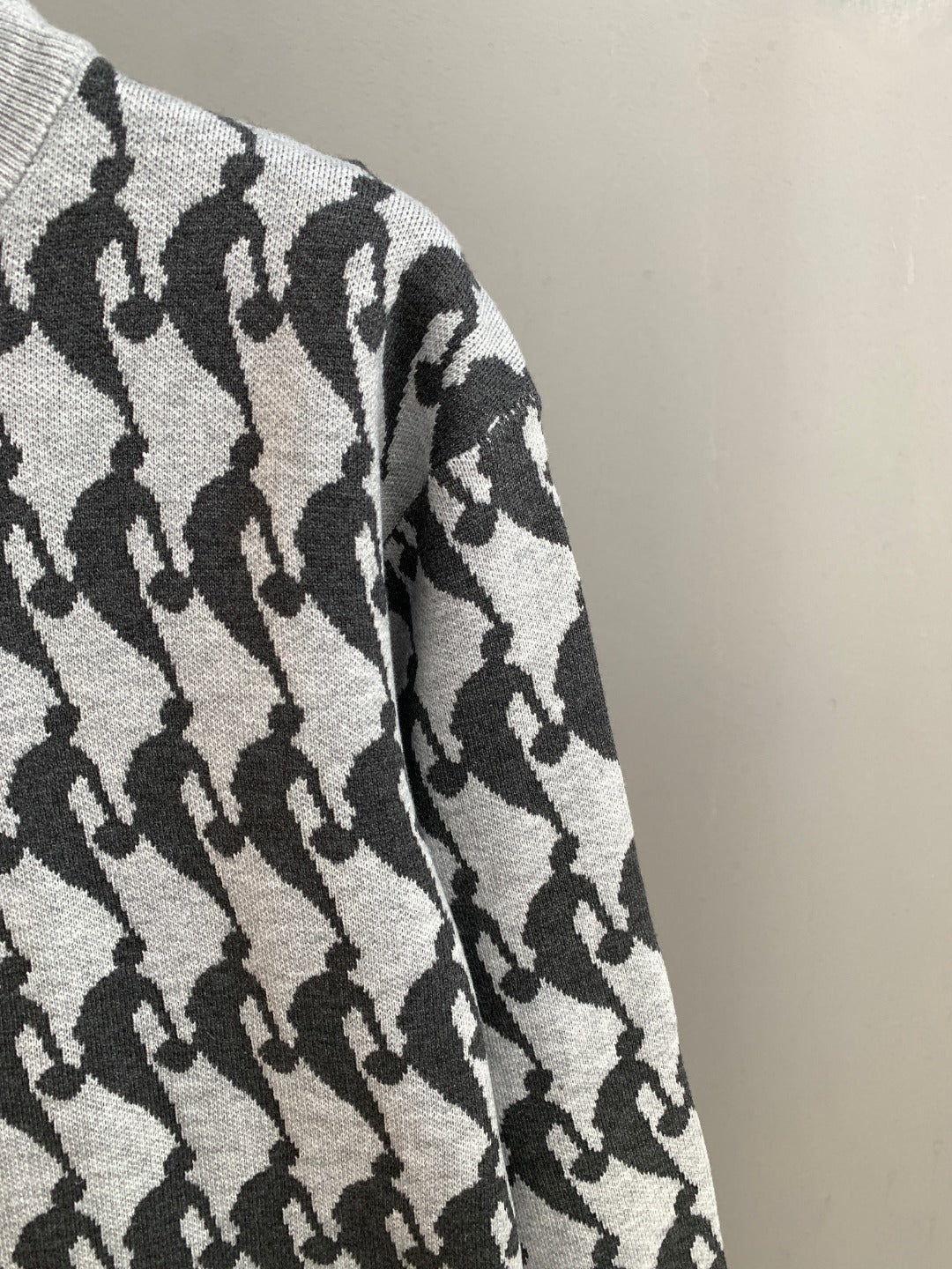 Long-sleeve sweater sleeve in light knit with repeating black silhouette pattern
