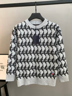 White and black patterned knit sweater, long sleeves, ribbed crew neck with dark trim