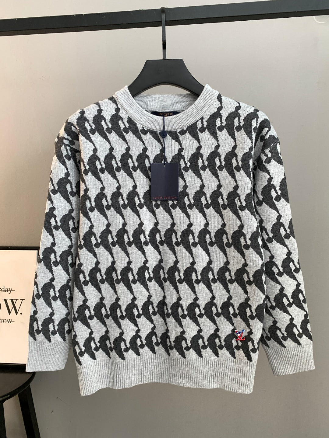White and black patterned knit sweater, long sleeves, ribbed crew neck with dark trim