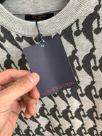 Long-sleeve sweater with black silhouette pattern and hanging brand tag