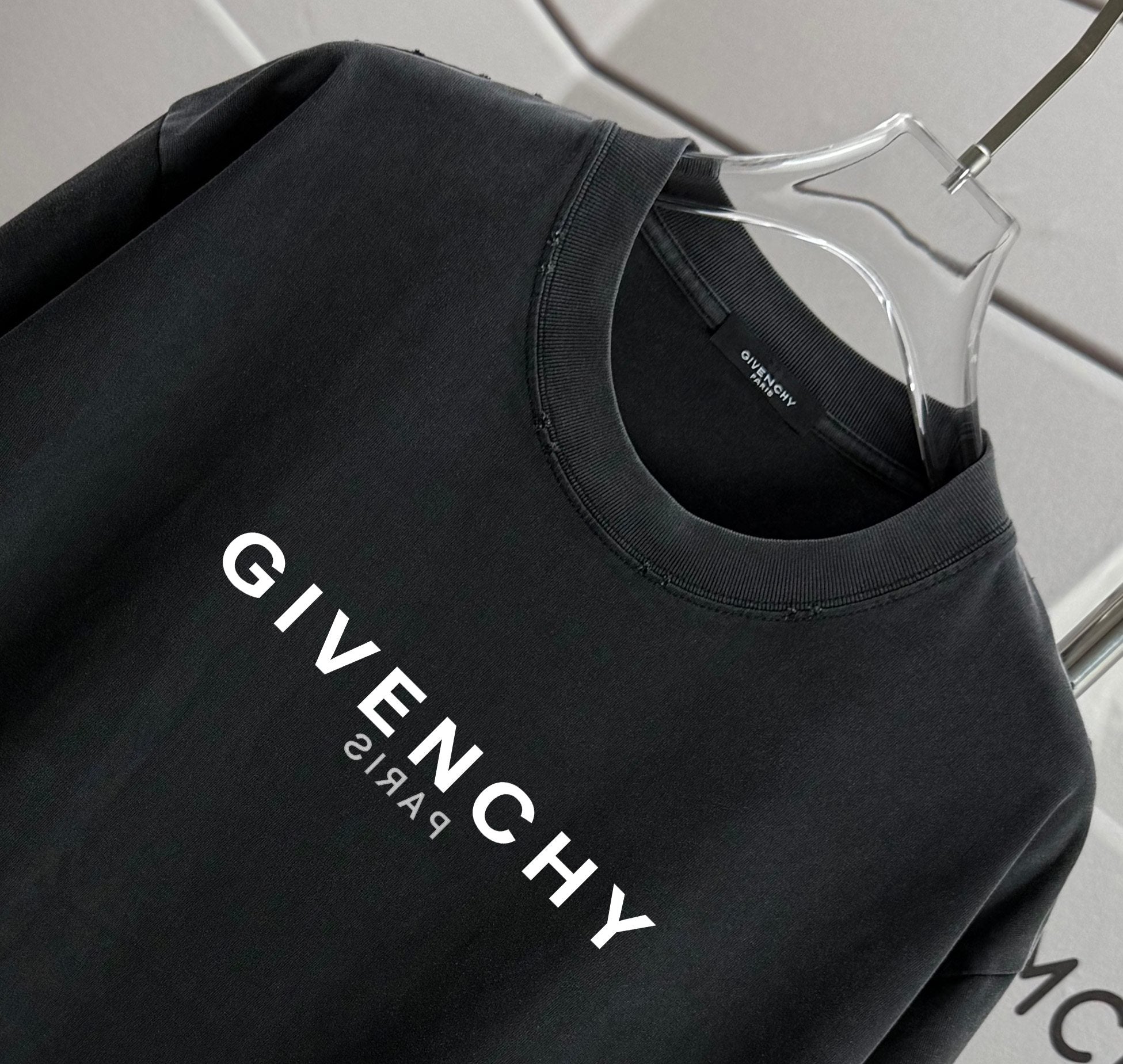 Black T-shirt with GIVENCHY logo print across the chest.