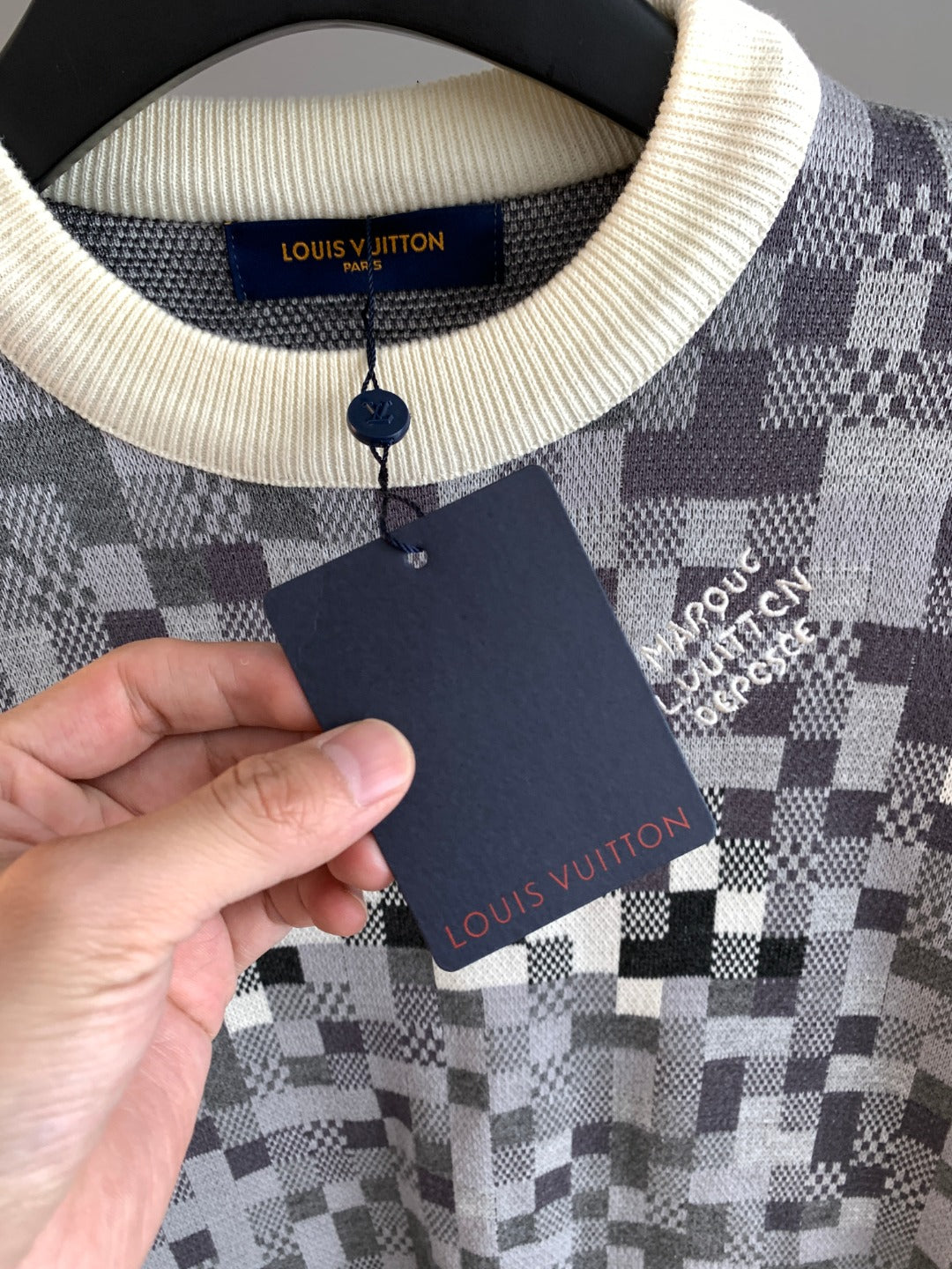 Louis Vuitton sweater neckline detail with cream ribbed collar and dark interior label