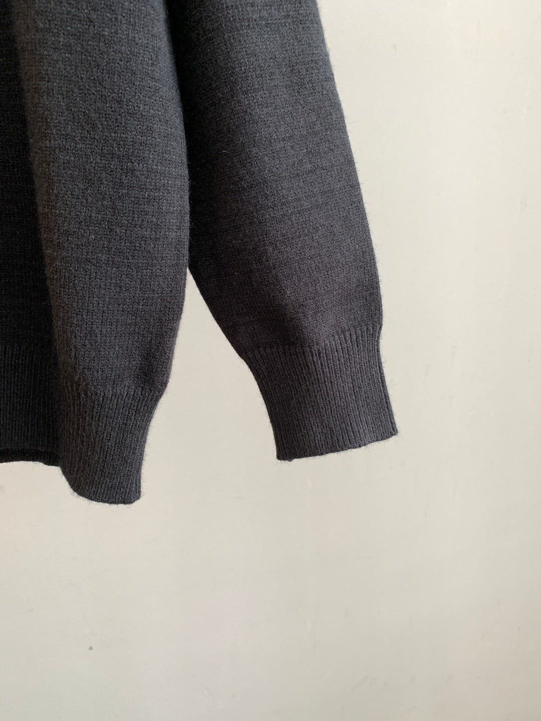 Charcoal knit sweater sleeve with ribbed cuff and textured knit hem