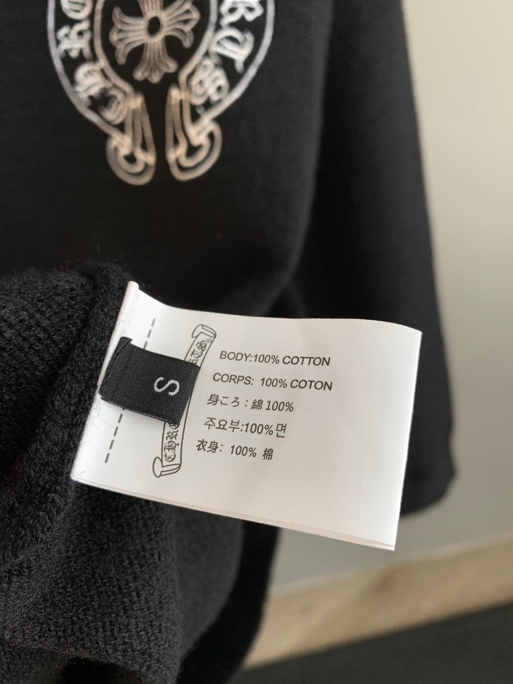 Charcoal cotton sweater care label inside neckline with fabric composition