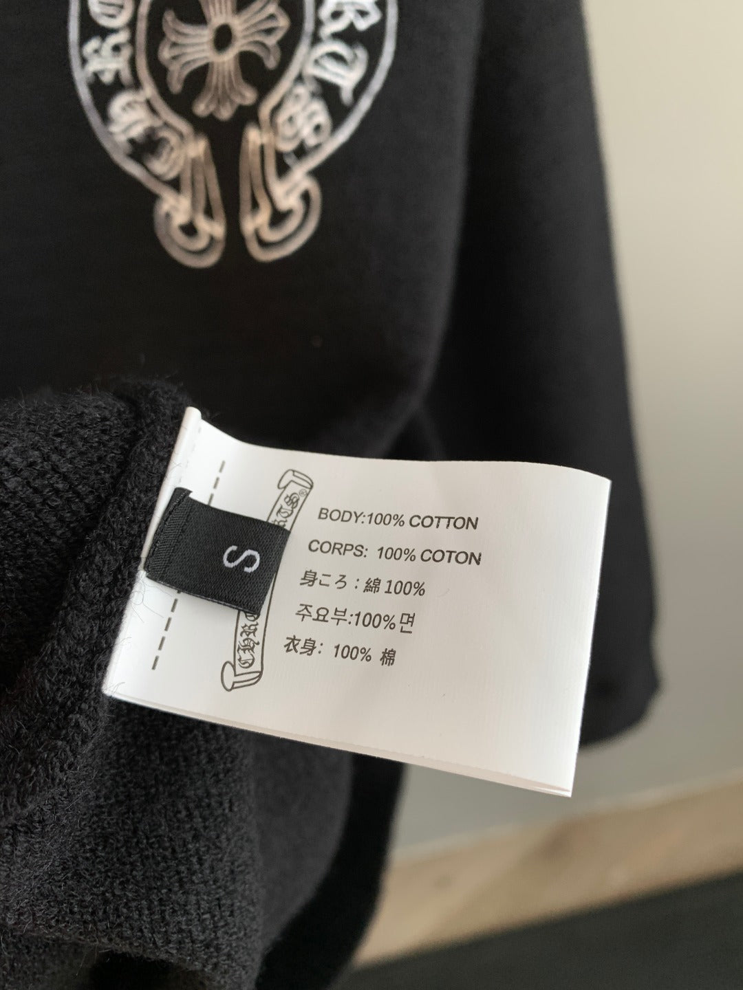 Charcoal cotton sweater care label inside neckline with fabric composition