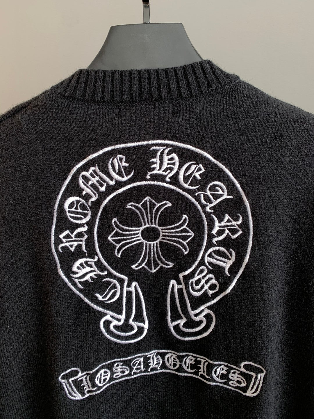 Charcoal knit long-sleeve sweater with large circular back logo and banner text