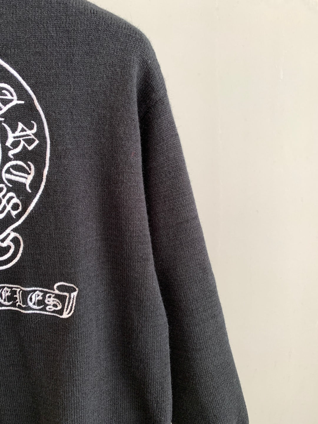 Charcoal knit sweater with partial side graphic logo and ribbed crew neckline