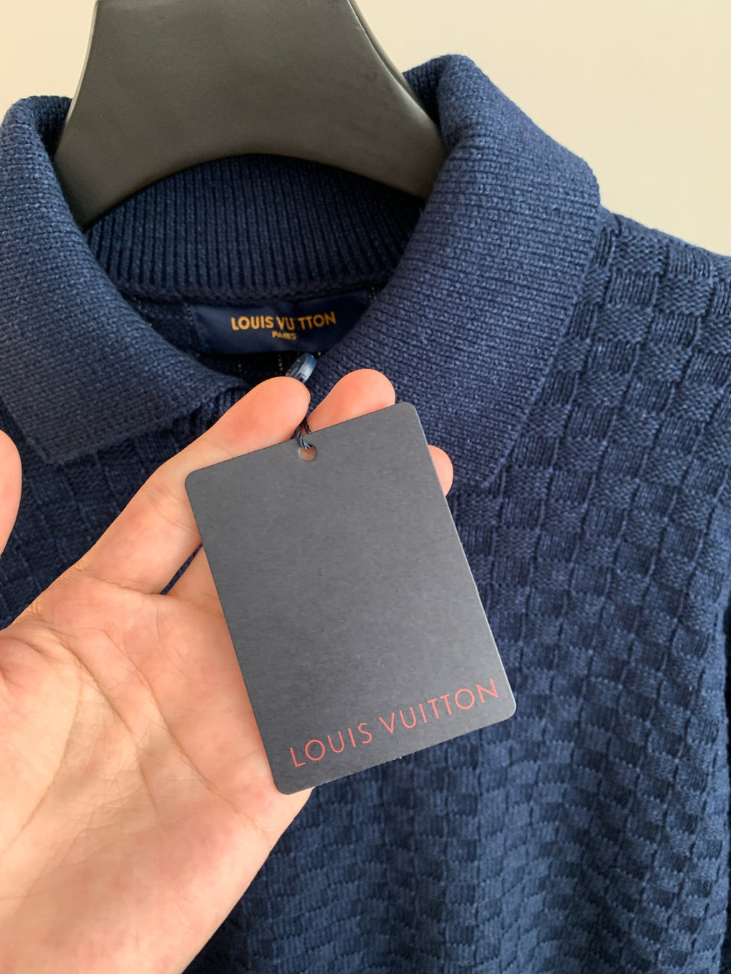 Blue knit sweater neck with Louis Vuitton label and hanging clothing tag
