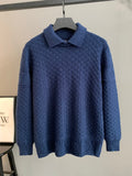 Blue knit sweater with point collar and long sleeves on hanger