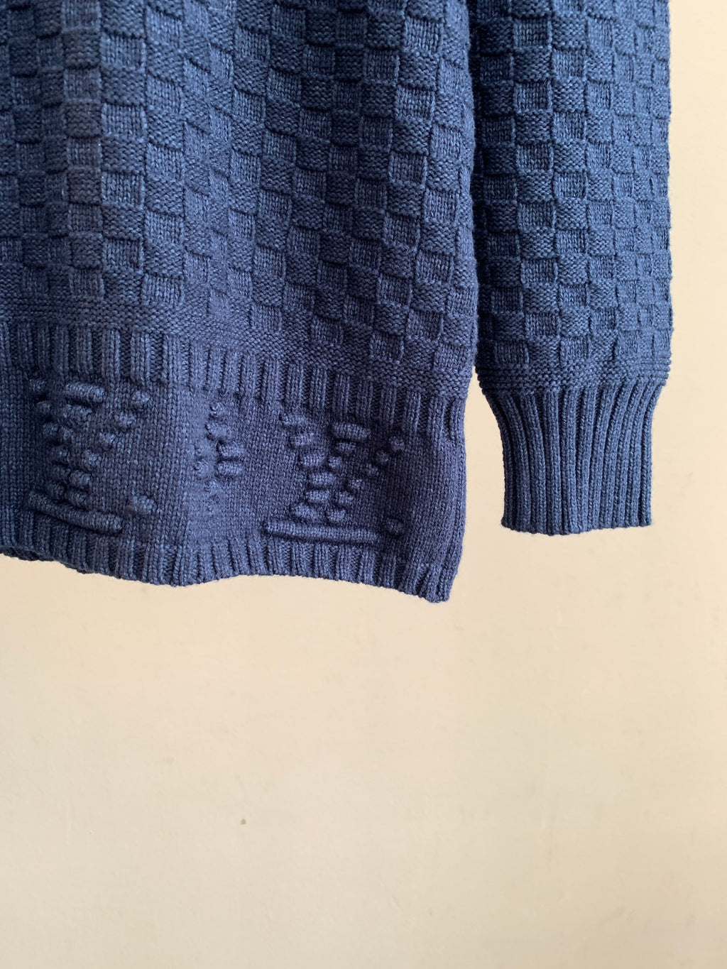 Blue knit sweater hem with ribbed cuff and textured stitch detailing