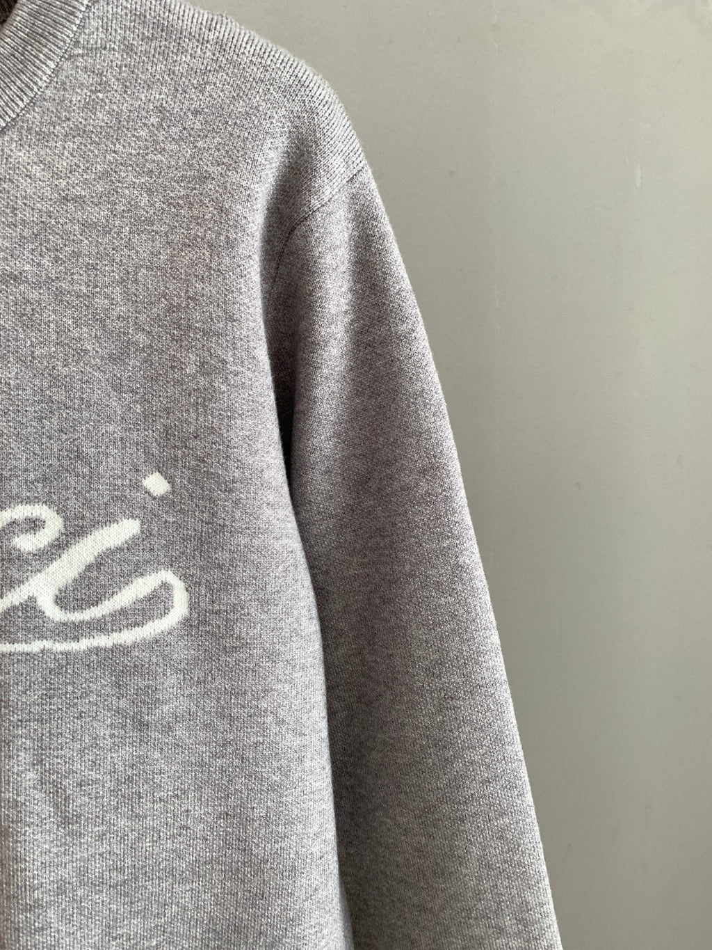 Grey knit sweatshirt sleeve, partial front