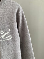 Grey knit sweatshirt sleeve, partial front