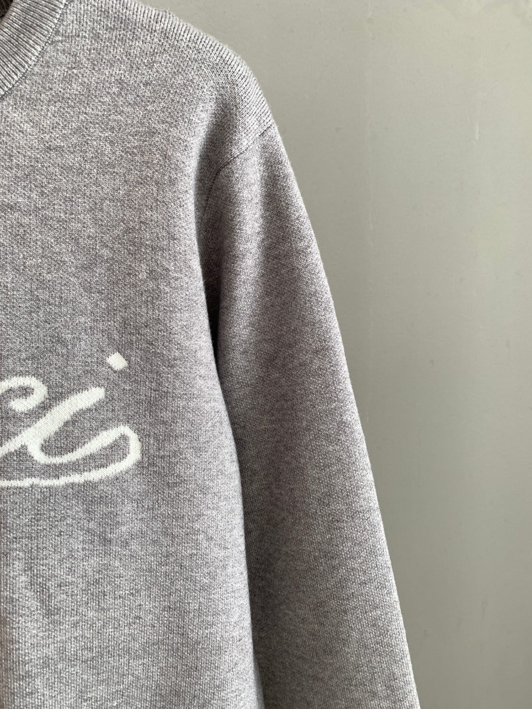 Grey knit sweatshirt sleeve, partial front