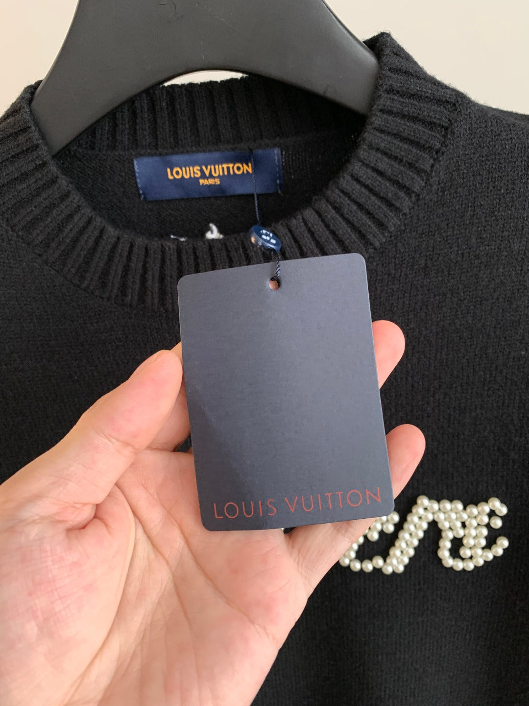 Charcoal knit sweater neckline with Louis Vuitton label and hanging size tag