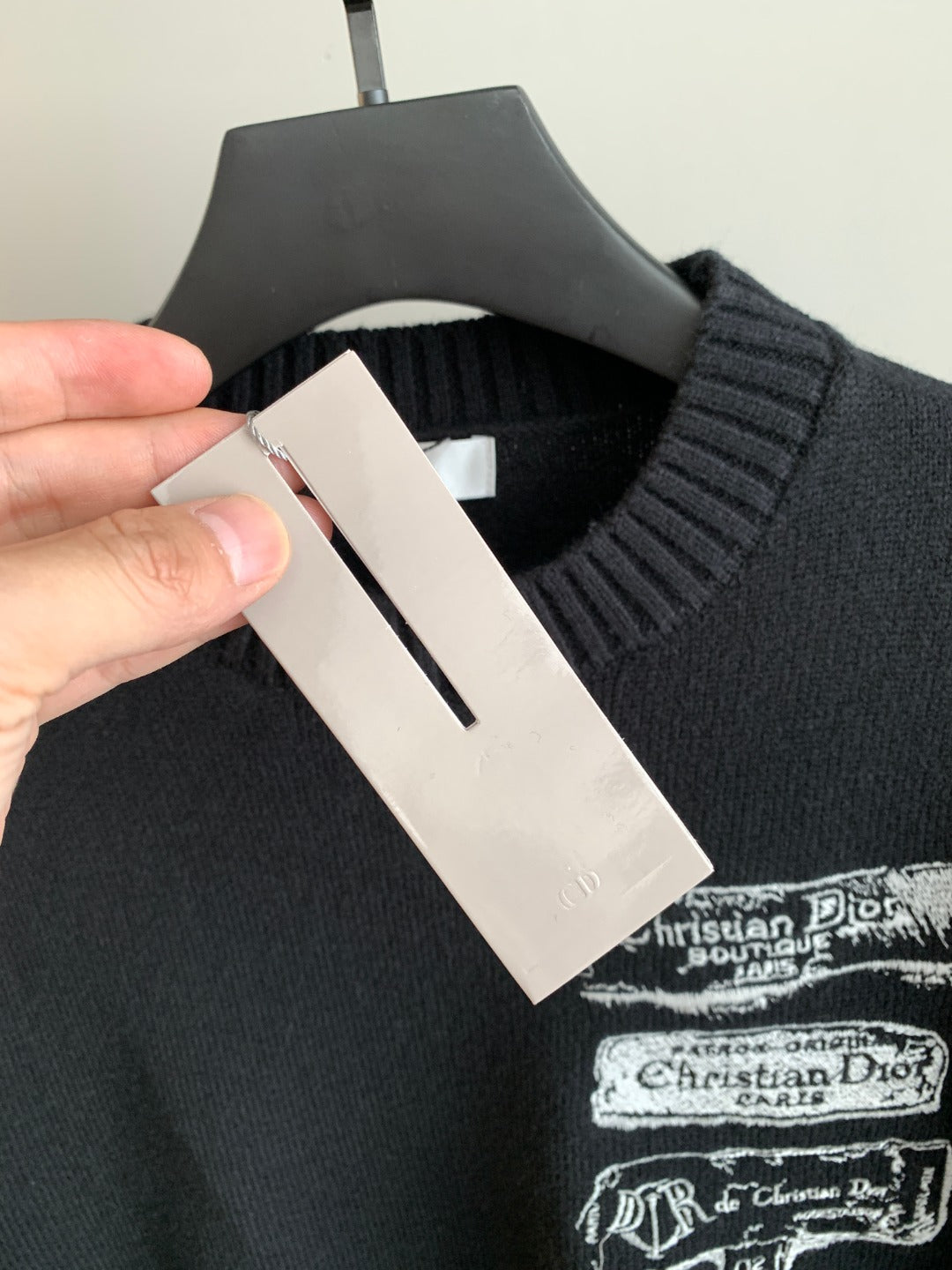 Dark knit sweater close-up with interior neck label and Dior logo print